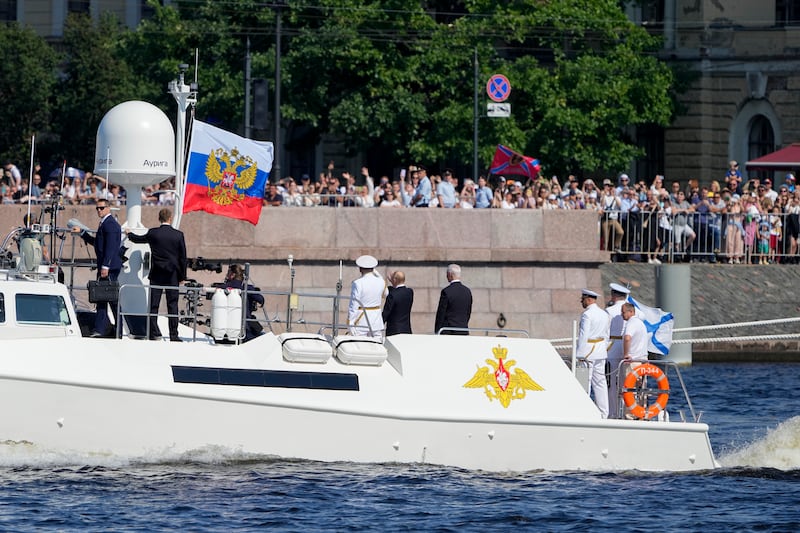 President Vladimir Putin and Russian officials wave to spectators during Navy Day in St Petersburg (Dmitri Lovetsky/Pool/AP)