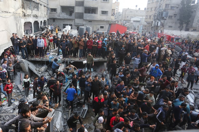 Palestinians look at the destruction after an Israeli strike in Rafah (Hatem Ali/AP)