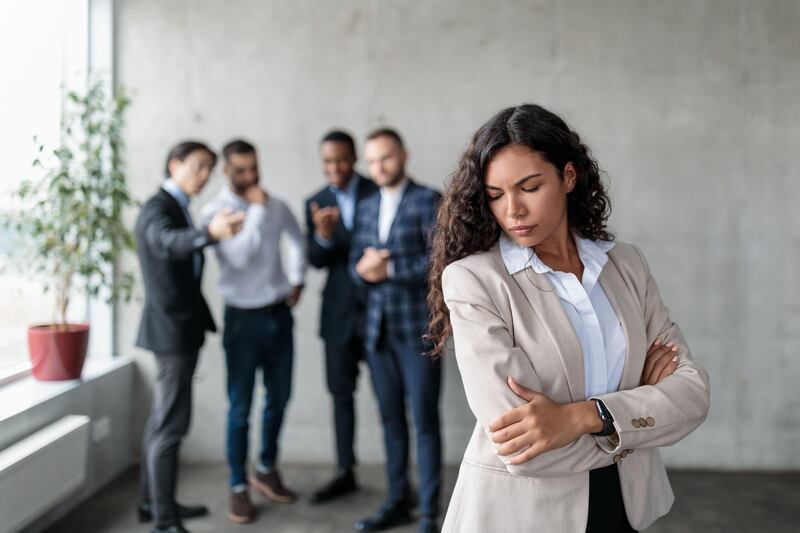 Unhappy businesswoman being bullied by her colleagues