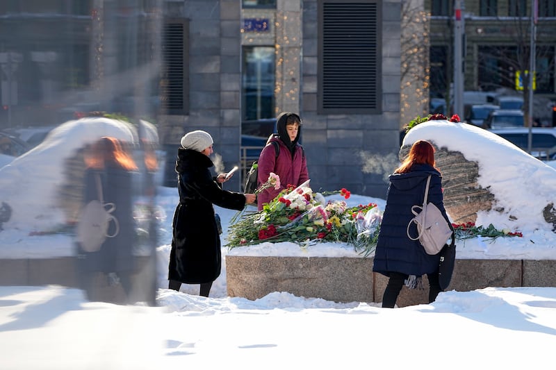 Youths lay flowers in Moscow, Russia (Alexander Zemlianichenko/AP)