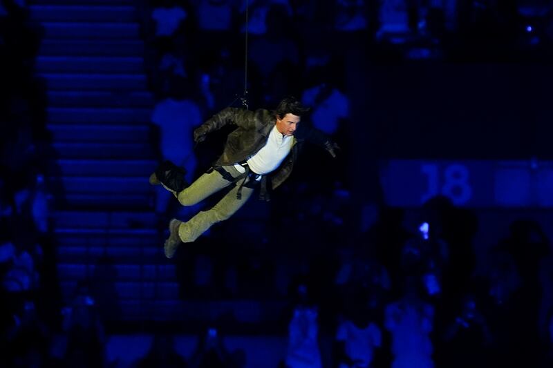 Tom Cruise jumps from the stadium roof during the closing ceremony