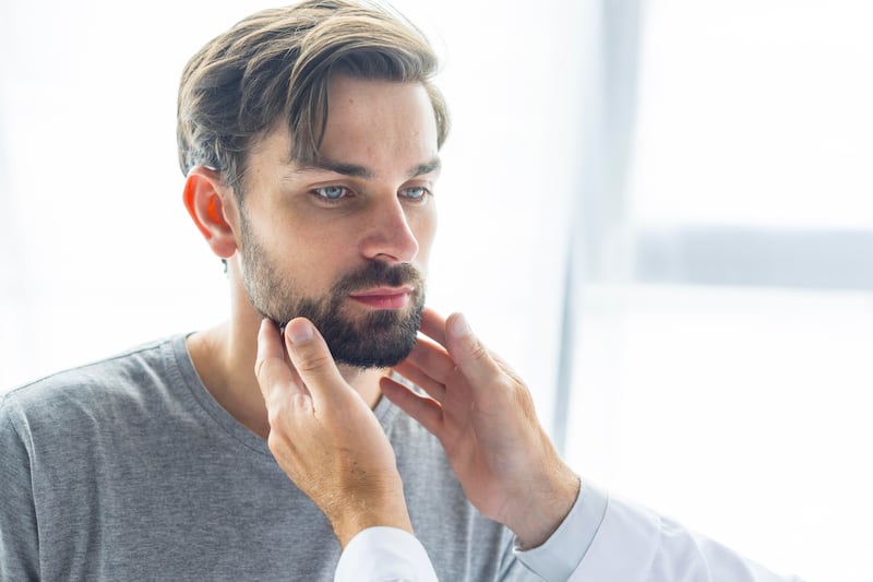 Doctor checking a young man’s lymph nodes