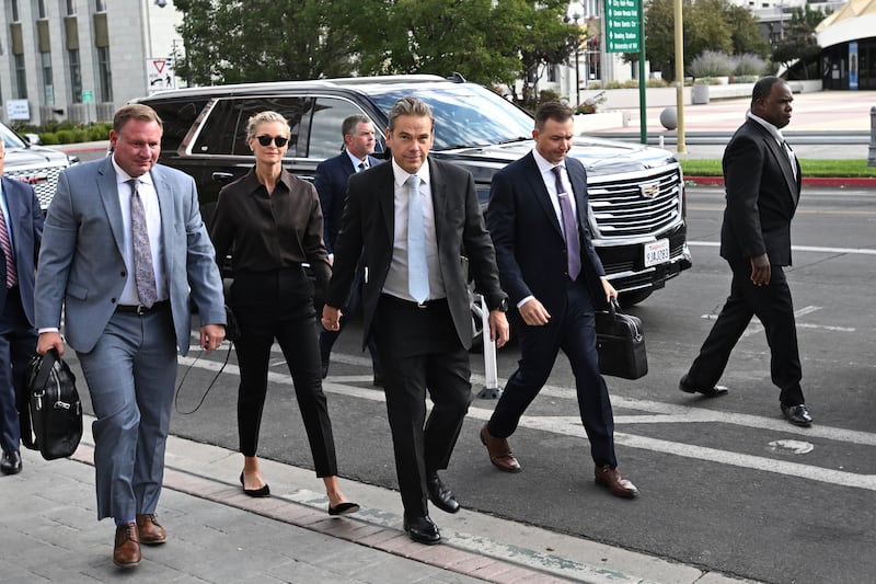 Lachlan Murdoch, centre, and his wife Sarah arrive at court in Reno (Andy Barron/AP)