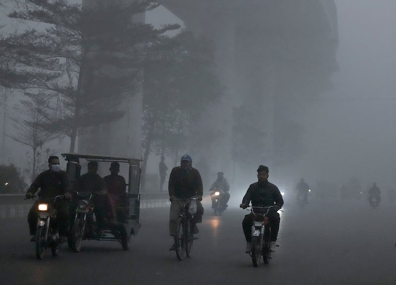 Motorcyclists move slowly due to reduced visibility caused by smog enveloping Lahore in Pakistan (KM Chaudary/AP)