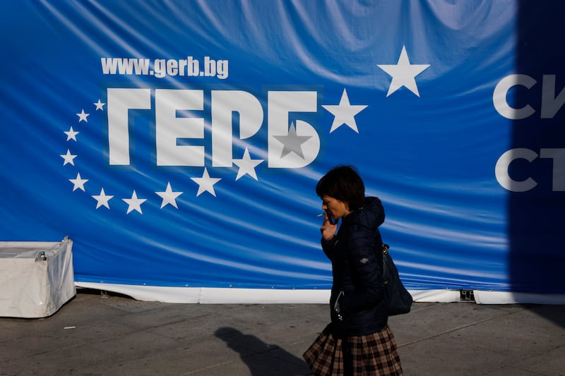 A woman walks in front of a GERB party poster in Sofia (Valentina Petrova/AP)