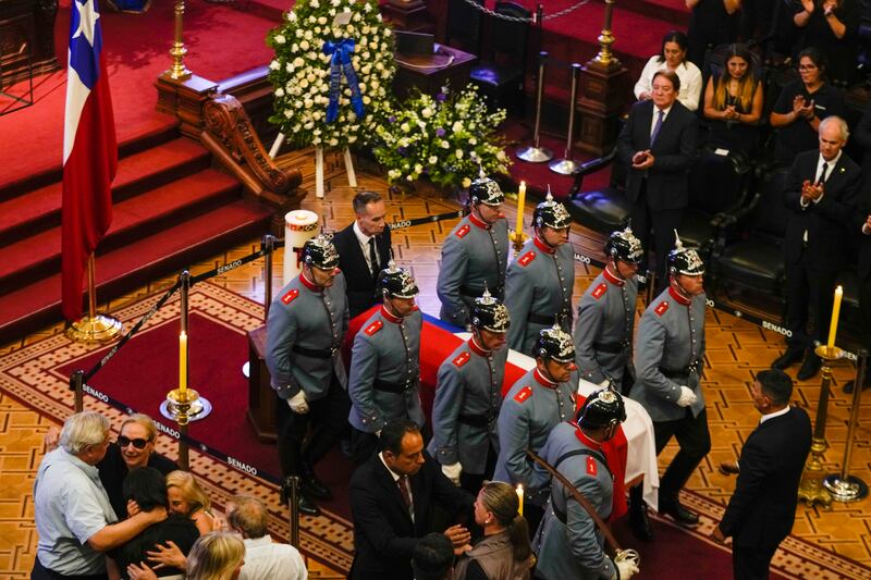 Cecilia Morel, bottom, left, the widow of former Chilean president Sebastian Pinera, receives condolences next to her husband’s coffin after it arrived at the Congress building in Santiago (Esteban Felix/AP)