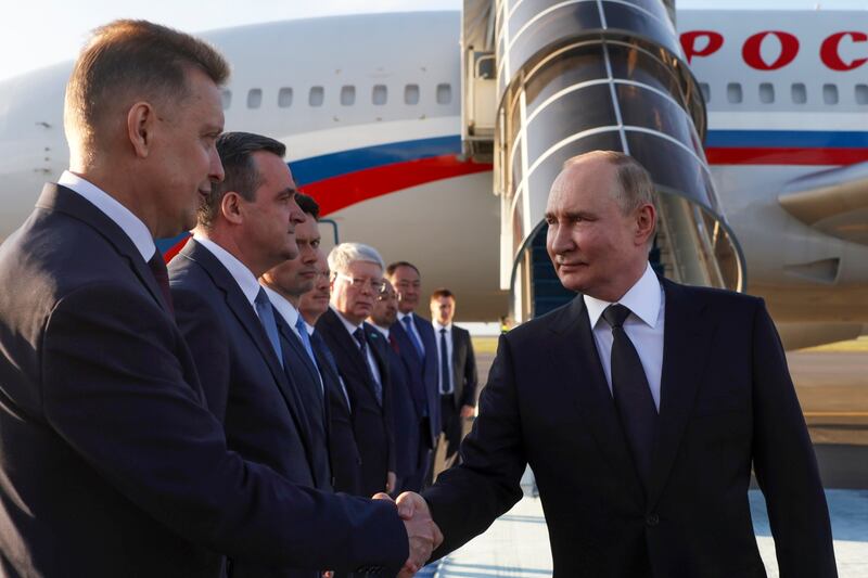 Vladimir Putin shakes hands with diplomats upon his arrival at the international airport in Astana (Gavriil Grigorov, Sputnik, Kremlin Pool Photo via AP)