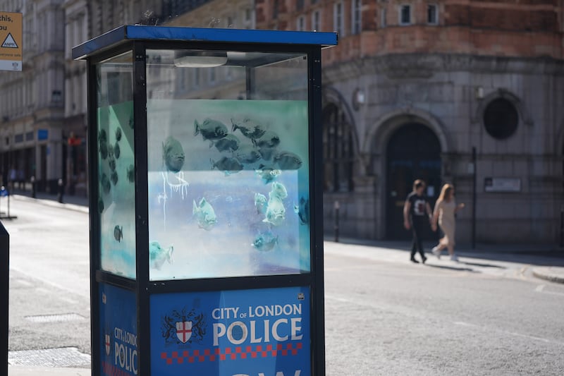 The new design of swimming piranhas appeared on a police box in the City of London on Sunday