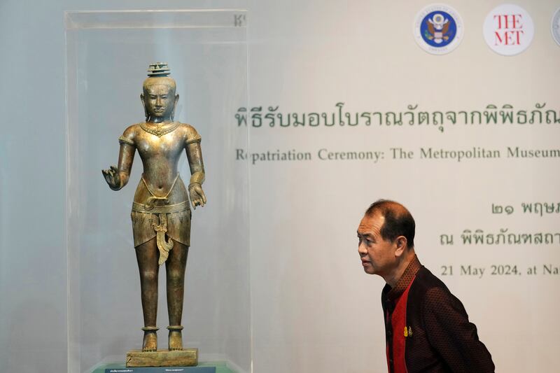 A Thai person looks at the Standing Shiva sculpture from the 11th century during a repatriation ceremony at the National Museum in Bangkok (Sakchai Lalit/AP)