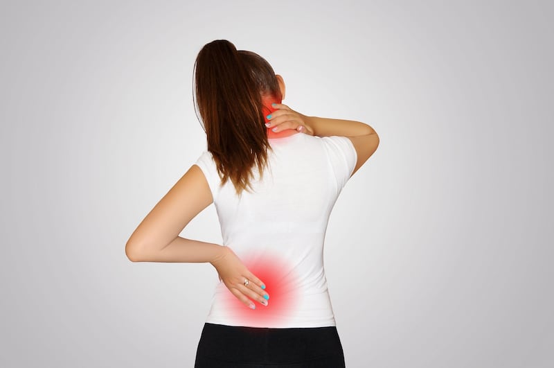 A photo of a young woman suffering from neck and back pains