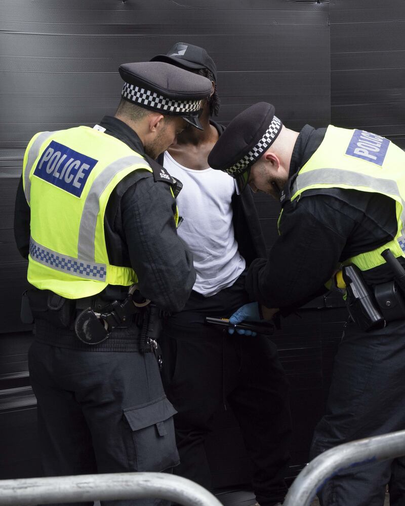 Police officers detain a man during the Notting Hill Carnival