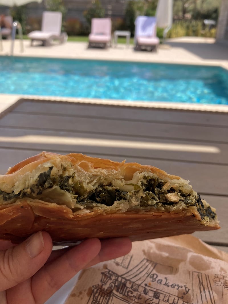 Tucking into spanakopita by the pool