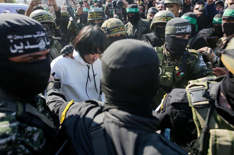 One of five Thai hostages is escorted by Hamas and Islamic Jihad fighters to the Red Cross in Khan Younis (Jehad Alshrafi/AP)