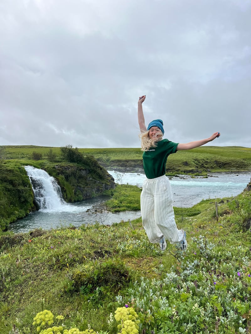 Jade jumping infront of a waterfall in Iceland