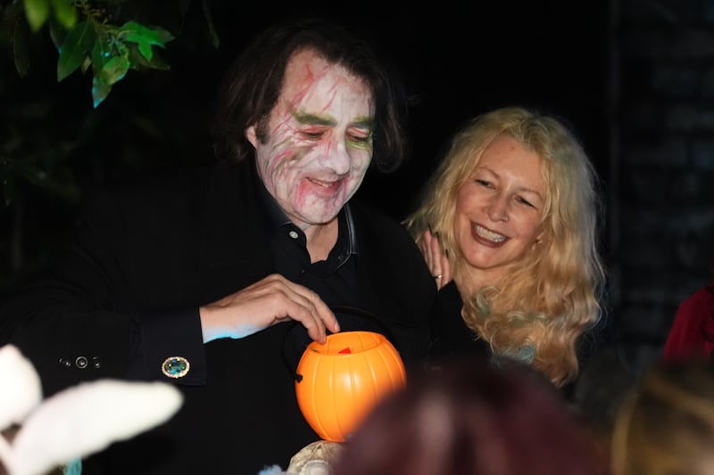 Jonathan Ross and his wife, Jane Goldman, outside their home handing out treats to trick-or-treaters