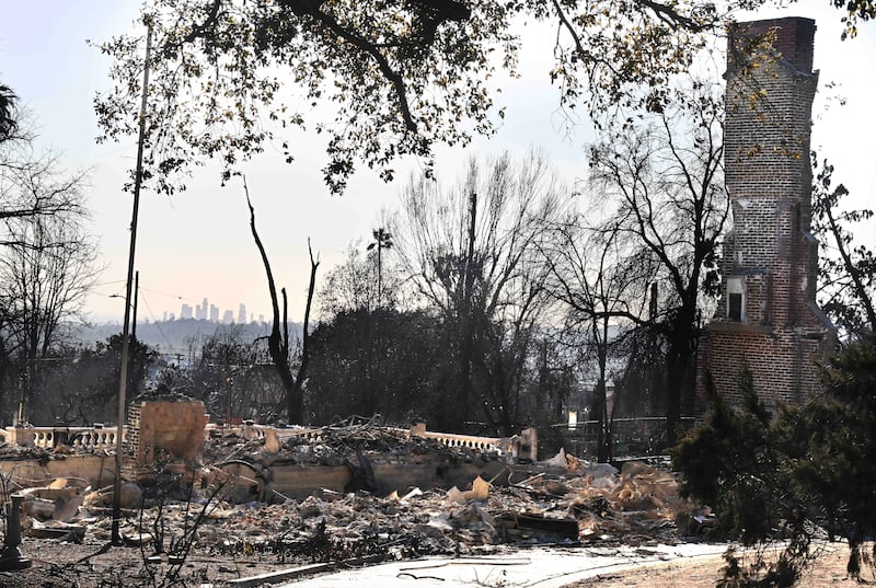 The Los Angeles skyline in the distance as a home burned by the Eaton Fire lies in ruins (Will Lester/The Orange County Register/AP)