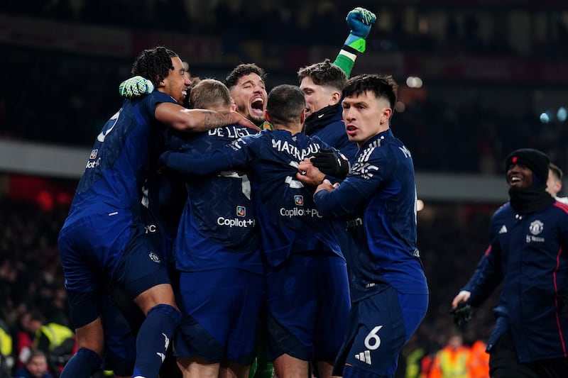 Altay Bayindir is mobbed by Manchester United players after the penalty shootout