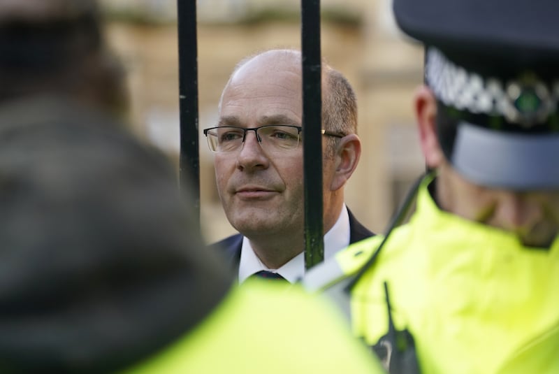 Tom Bradshaw, president of the National Farmers’ Union, talks to protesting farmers through gates outside the Oxford Farming Conference