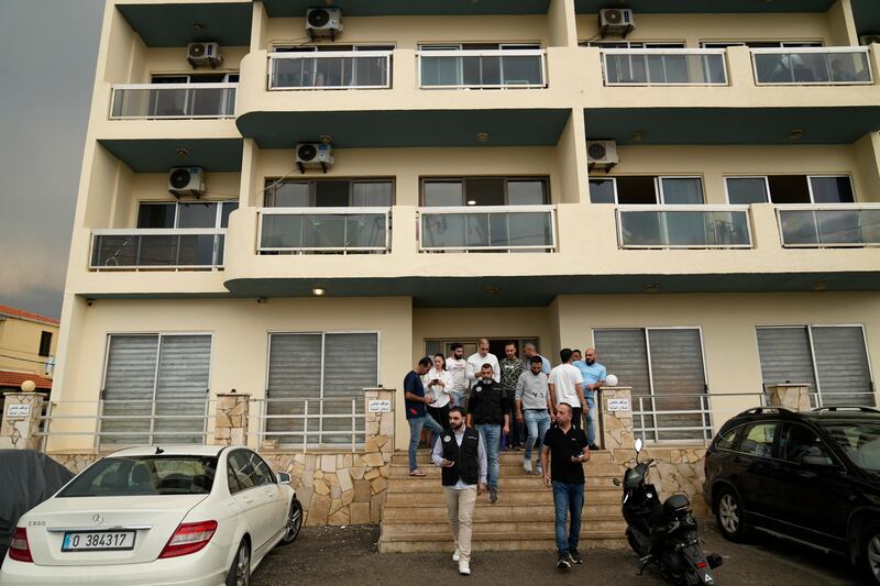 Lebanese intelligence officers leave a building in Batroun (Hussein Malla/AP)