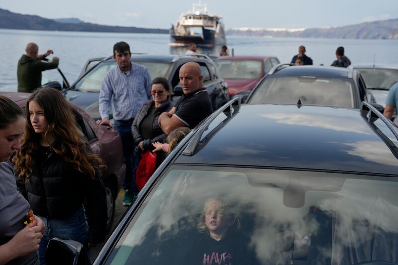 People wait for the arrival of a ferry to Athens’ port of Piraeus (Petros Giannakouris/AP)