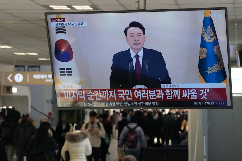 A TV screen shows South Korean President Yoon Suk Yeol’s televised briefing at a bus terminal in Seoul (Ahn Young-joon/AP)