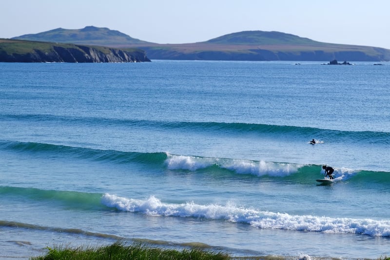 Surfer riding a wave at Whitesands Bay in Pembrokeshire, West Wales