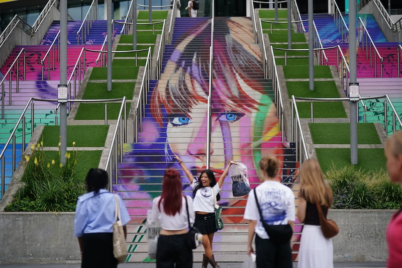 A fan takes a photograph at the Swiftie Steps and murals at Wembley Park, north west London