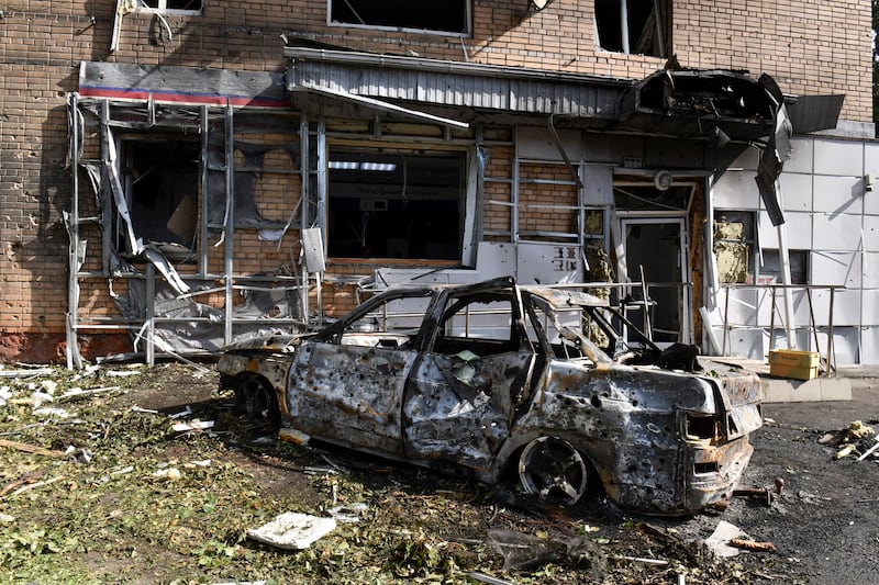 A burned car is seen in front of an apartment building damaged after shelling by the Ukrainian side in Kursk