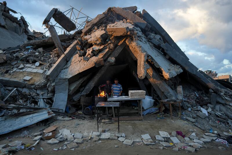 A man sells bread under the wreckage of his bakery destroyed by an Israeli air and ground offensive in Jabaliya, Gaza Strip (Abdel Kareem Hana/AP)