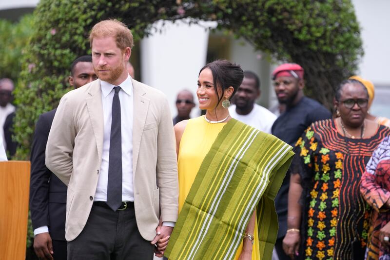 Harry and Meghan hold hands upon arrival at the government house in Lagos (Sunday Alamba/AP)