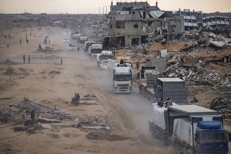 Humanitarian aid trucks enter through the Kerem Shalom crossing from Egypt into the Gaza Strip, in Rafah, on Wednesday (Jehad Alshrafi/AP)