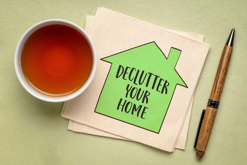 2WT9AAF declutter your home motivational reminder – handwriting and sketch on a napkin with a cup of tea, simplicity and minimalism concept