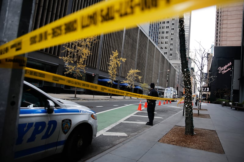 A police officer stands on 54th Street outside the Hilton Hotel in midtown Manhattan where Brian Thompson was fatally shot (AP Photo/Stefan Jeremiah)