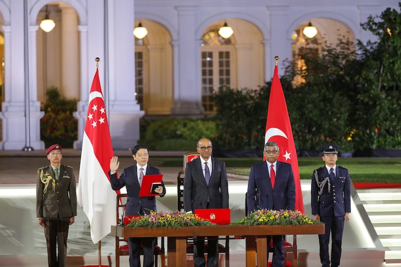 Mr Wong, second from left, is sworn in next to president Tharman Shanmugaratnam, centre, and chief justice Sundaresh Menon, second from right, at the Istana in Singapore (Ministry of Communications and Information via AP)