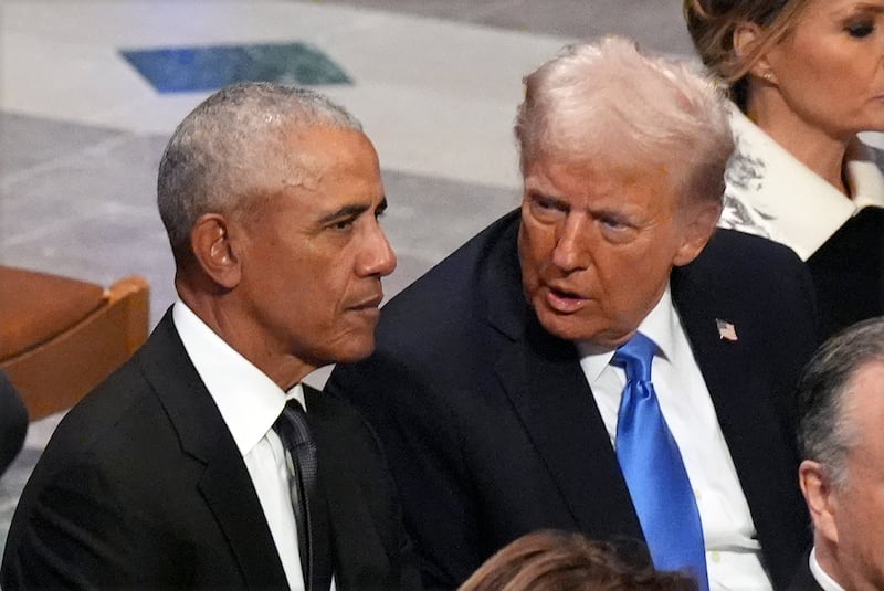 Mr Trump speaks with former president Barack Obama before the state funeral for former president Jimmy Carter (Jacquelyn Martin/AP)