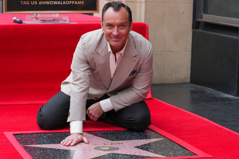 Jude Law poses with his new star at a ceremony honouring him on the Hollywood Walk of Fame (Jordan Strauss/Invision/AP)