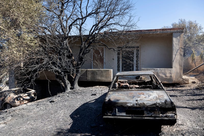 A burnt car in the garden of a house near Athens (Yorgos Karahalis/AP)