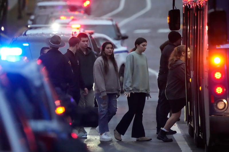 Students aboard a bus as they leave the shelter following a shooting at the Abundant Life Christian School (Morry Gash/AP)