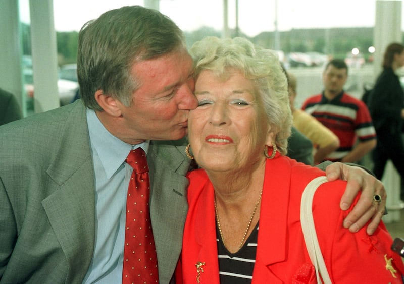 Manchester United manager Sir Alex Ferguson gives his former schoolteacher Elizabeth Thomson, 73, a kiss on the cheek when at an Asda store in Govan, Glasgow