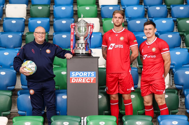 A Portadown coach, Jack Duncan and Eamonn Fyfe standing beside the Sports Direct NIFL Premiership trophy