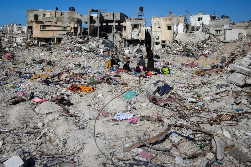 Palestinians search for their belongings under the rubble of destroyed homes in Rafah (Abdel Kareem Hana/AP)