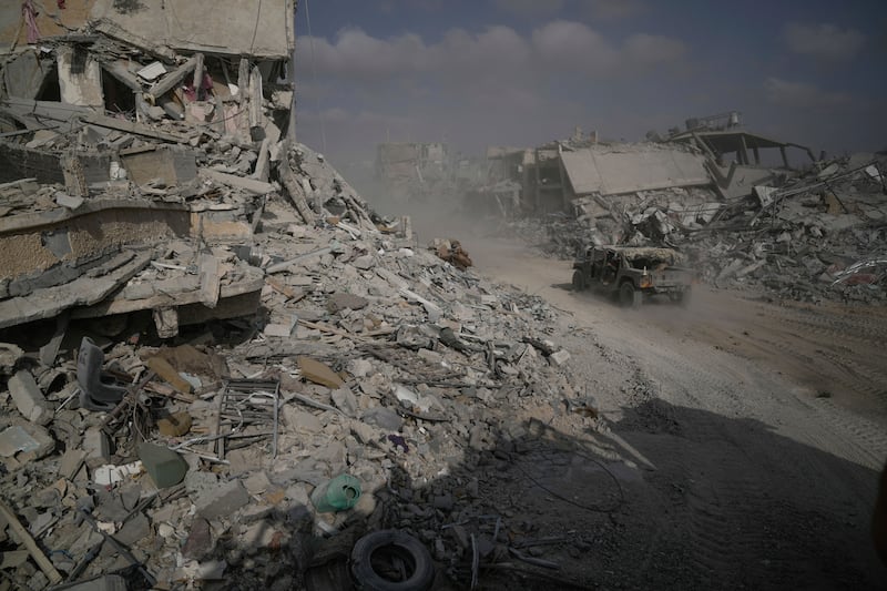 Israeli soldiers drive near destroyed buildings during a ground operation in the Gaza Strip (Leo Correa/AP)