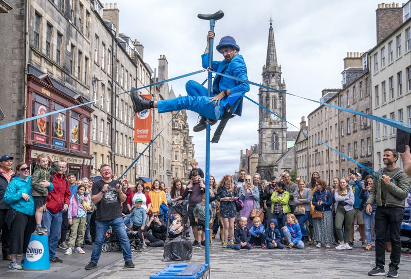 A street performer entertains the crowds on Edinburgh’s Royal Mile as part of the Fringe