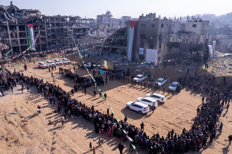 Red Cross vehicles, left, wait for the hand-over of Israeli soldier hostage Agam Berger at the Jabalya refugee camp in Gaza City (AP Photo/Mohammad Abu Samra)