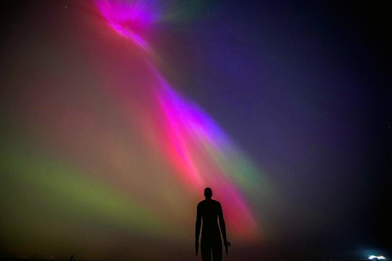 The aurora borealis seen on the horizon at Crosby Beach, Liverpool