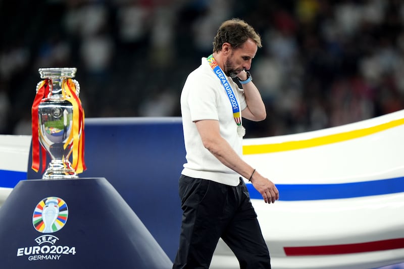 Gareth Southgate walks dejected past the Euro 2024 trophy