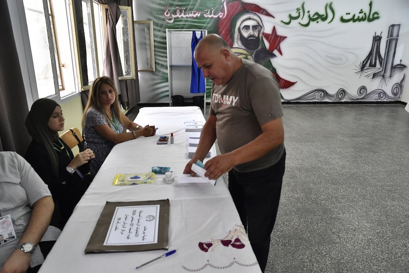 A voter prepares to cast his ballot inside a polling station during the presidential election (Fateh Guidoum/AP)