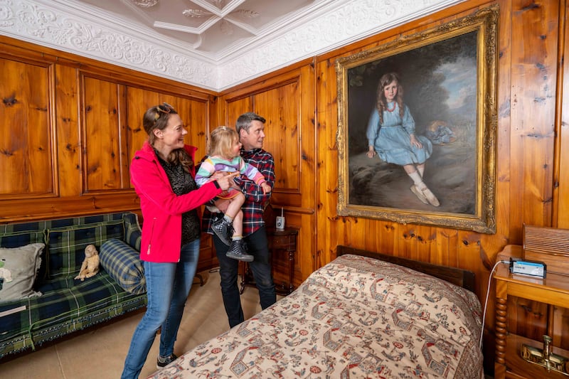 Visitors inside Craigievar Castle examine one of its paintings.