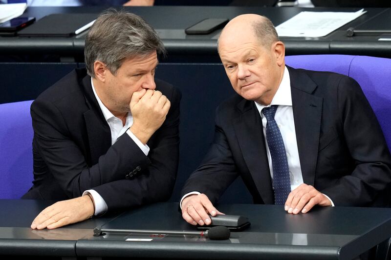 Chancellor Olaf Scholz, right, chats with economy and climate minister Robert Habeck in the German parliament (Ebrahim Noroozi/AP)