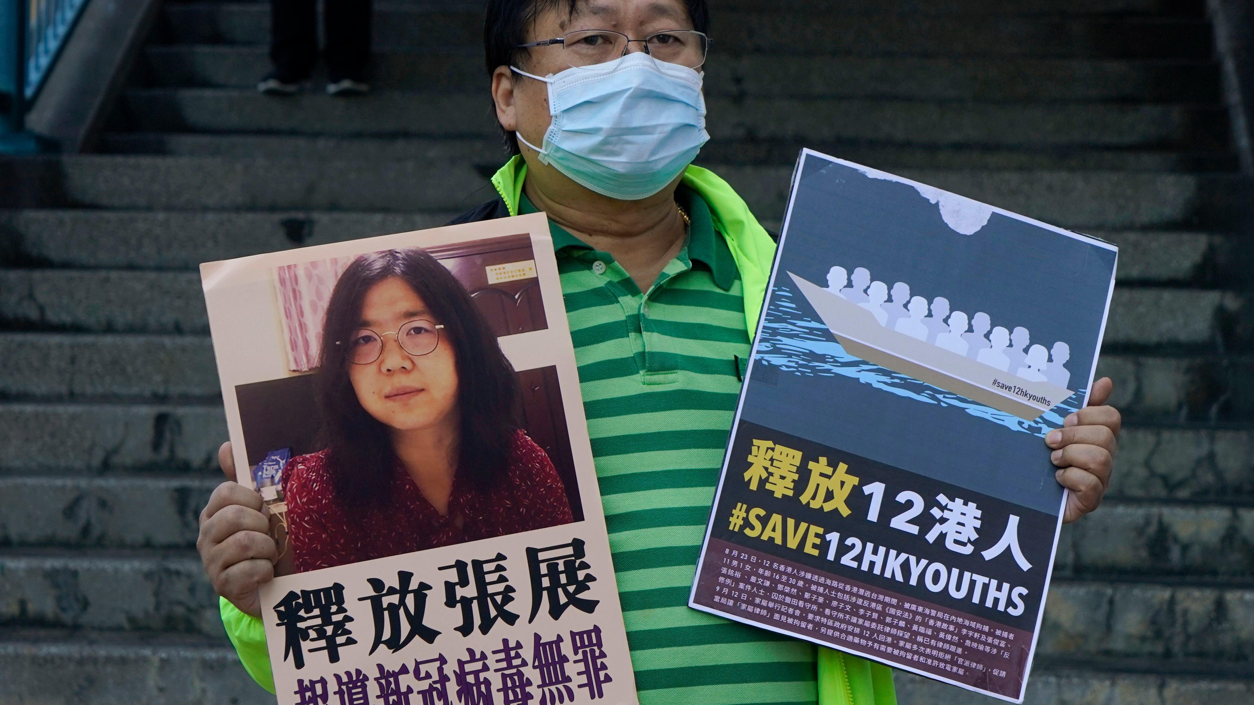 A pro-democracy activist holds placards with the picture of Chinese citizen journalist Zhang Zhan outside the Chinese central government’s liaison office, in Hong Kong (Kin Cheung/AP)